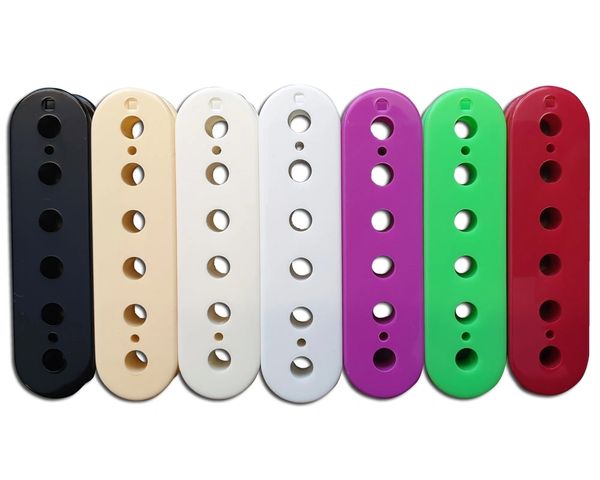 Seven colorful guitar pickup covers in various colors arranged in a row.