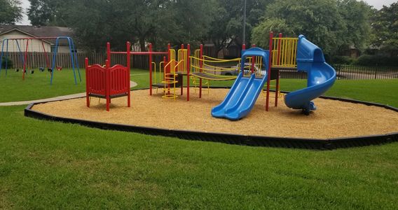 View of our neighborhood park with play ground, swings, and park benches.