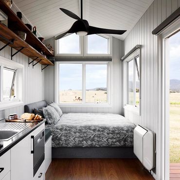 Hounds Run Vineyard Tiny House interior showing a queen bed and part of the kitchenette