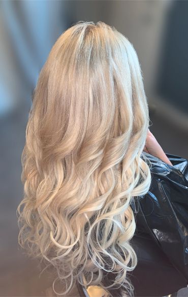 Long, wavy platinum blonde hair styled elegantly.