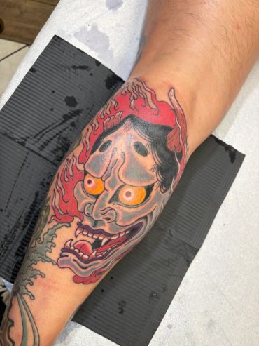 Colorful traditional Japanese demon tattoo on leg.