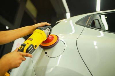 Technician buffing a white car