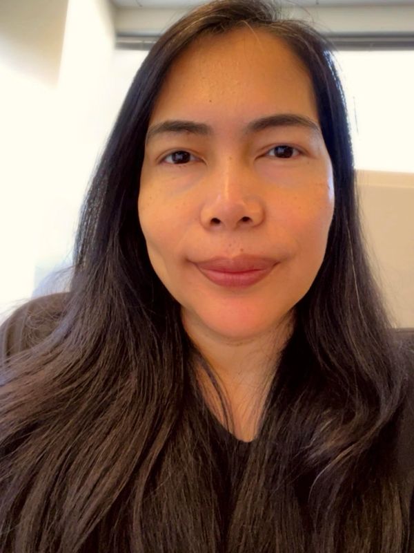 Woman with long dark hair and a calm expression.