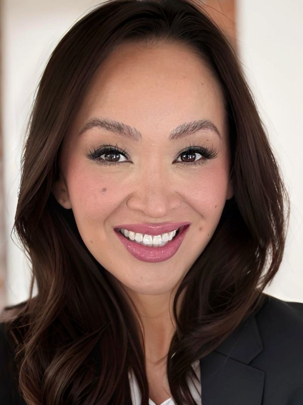 Smiling woman with long dark hair and professional attire.