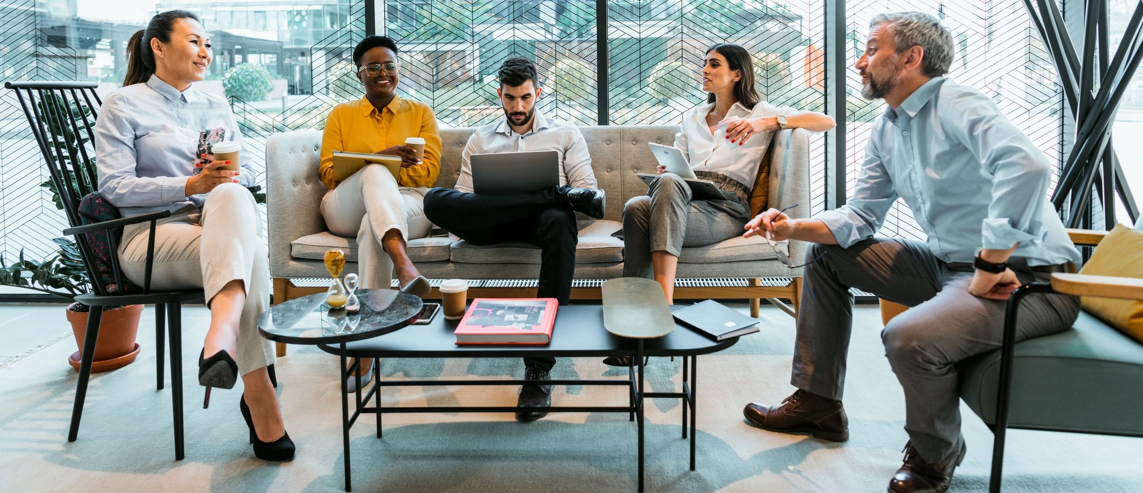 Business people discussing documents working on a laptop in a semi-casual business setting