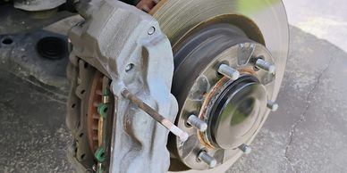Car brake disc and caliper assembly without the wheel.
