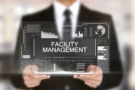 Businessman holding a digital screen with facility management graphics.