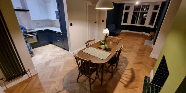 Spacious dining area with wooden table and chairs in an open-plan kitchen and living room.