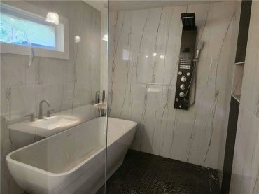 Modern bathroom with a freestanding tub and advanced shower panel.