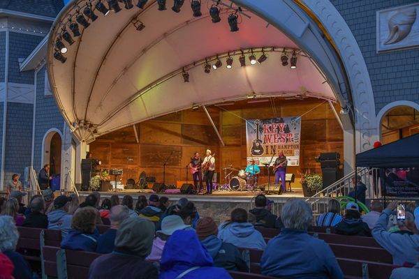 Band performing on outdoor stage with audience.