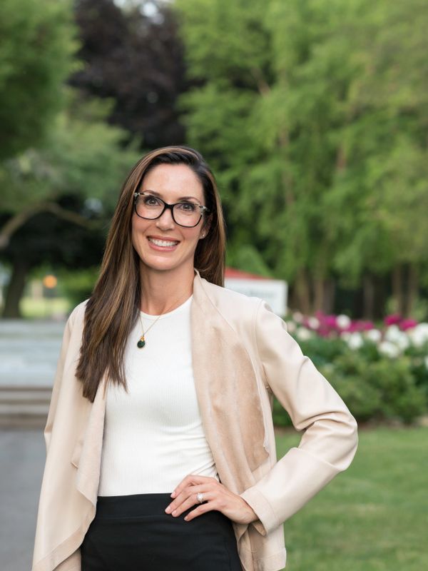 woman with glasses standing outside by flowers