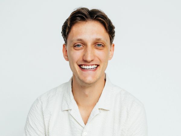 Smiling young man with blue eyes wearing a white shirt against a plain background. Realtor Real estate services springfield mo