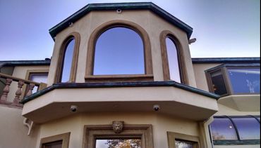 Architectural detail of a building with arched windows and a lion head ornament.
