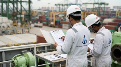 Two engineers inspecting documents at a shipping dock.
