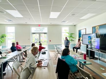 People attending a presentation or workshop in a bright, modern classroom setting.