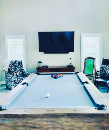 Modern game room with a pool table and wall-mounted TV.