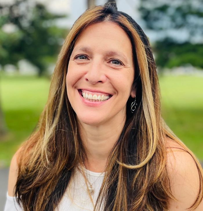 A woman smiling outside