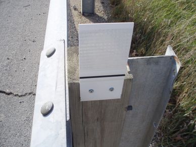 Delineator/Reflector for guardrail.  Mounts to the front of the existing wood or metal post.