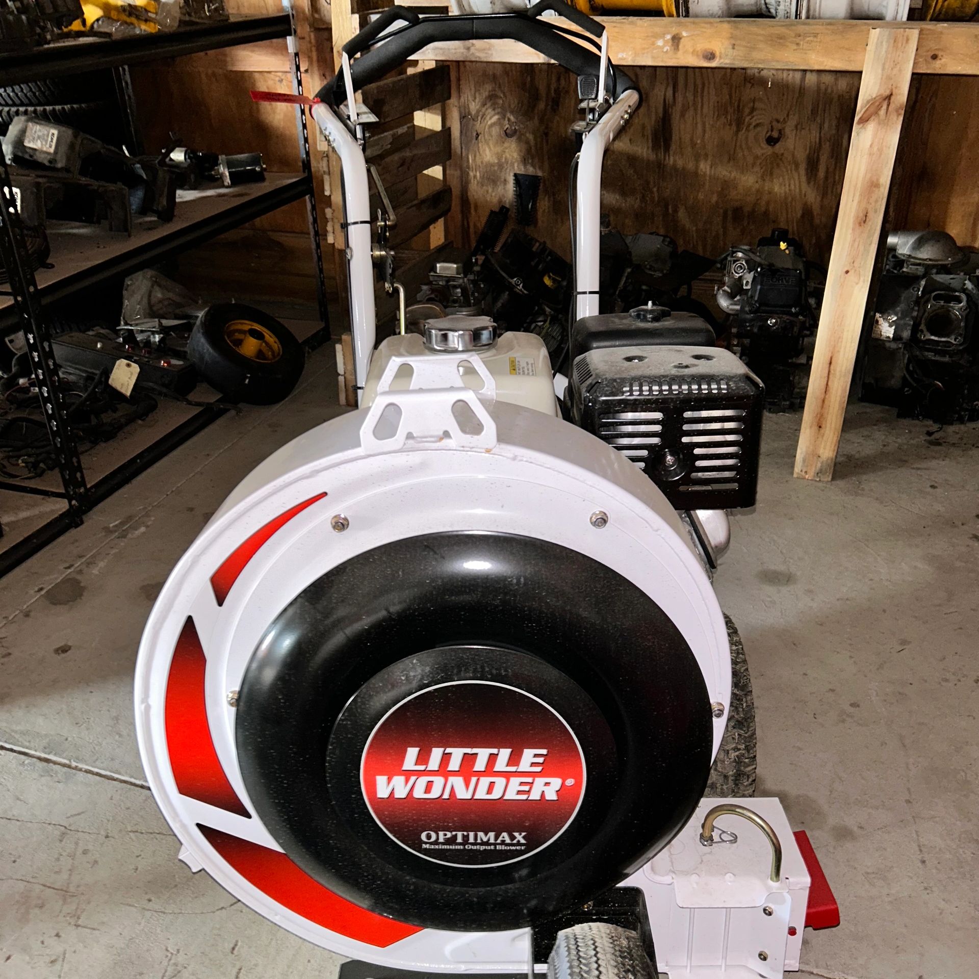 Close-up of a Little Wonder Optimax leaf blower in a garage with tools around.