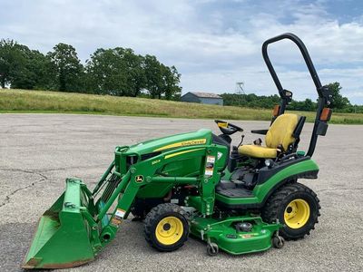 John Deere 1025R with front bucket and belly mower.