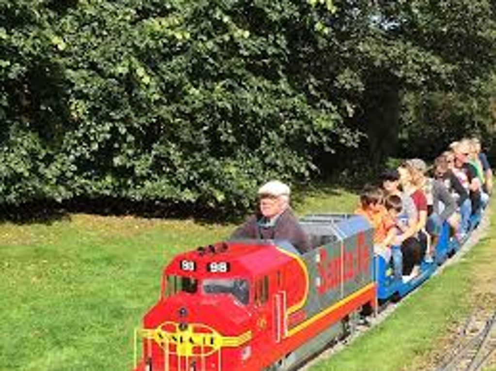 Children enjoying a ride on a miniature train in a park.