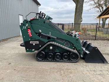 Compact green mini skid steer loader with tracks and front bucket attachment.