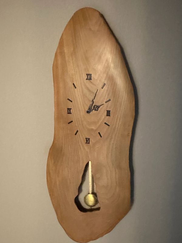 Wooden wall clock with Roman numerals and pendulum.