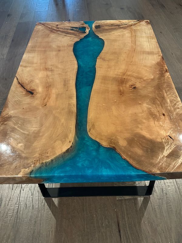 Wooden table with a blue resin river design.