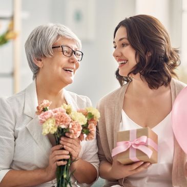 deux femmes qui tienent un bouquet de fleurs en main
