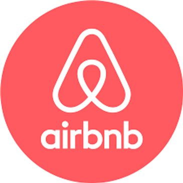 White Airbnb logo on a red circular background.
