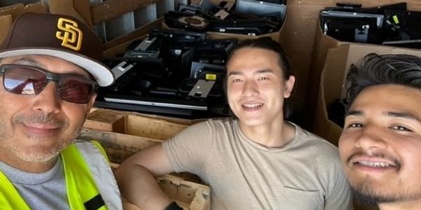 Three SDFF staff taking a picture with our donated e-waste, that's then repurpose and refurbished.