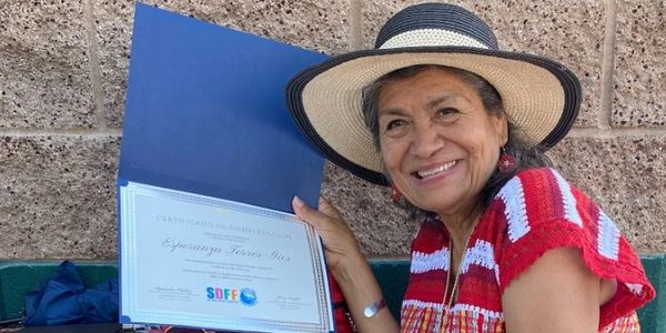 An image of a digital literacy student showcasing her certificate of completion of one our classes.