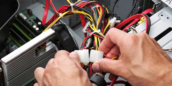 Image of someone connecting hardware to a desktop.