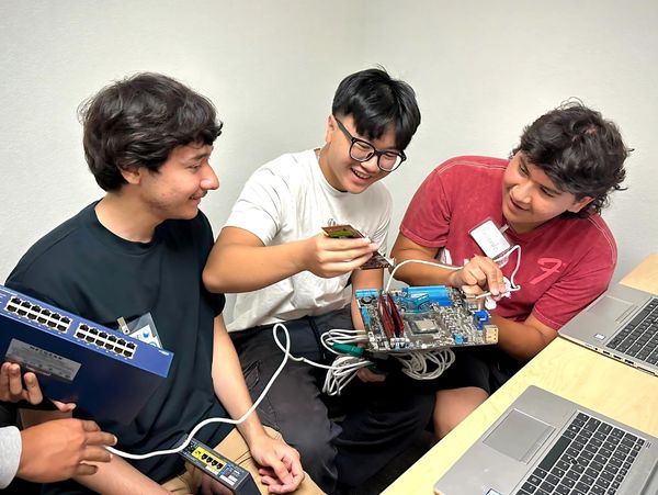 Group of students looking at tech.
