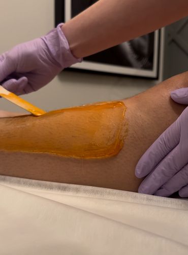 Applying warm wax for leg hair removal.