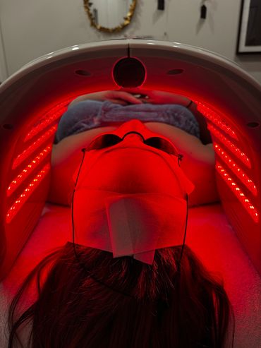 Person undergoing red light therapy wearing protective glasses.