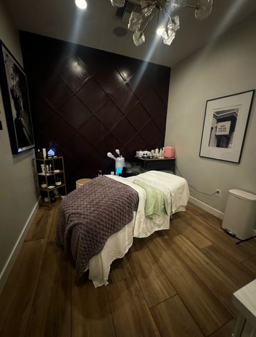 Cozy massage room with a treatment table and warm lighting.