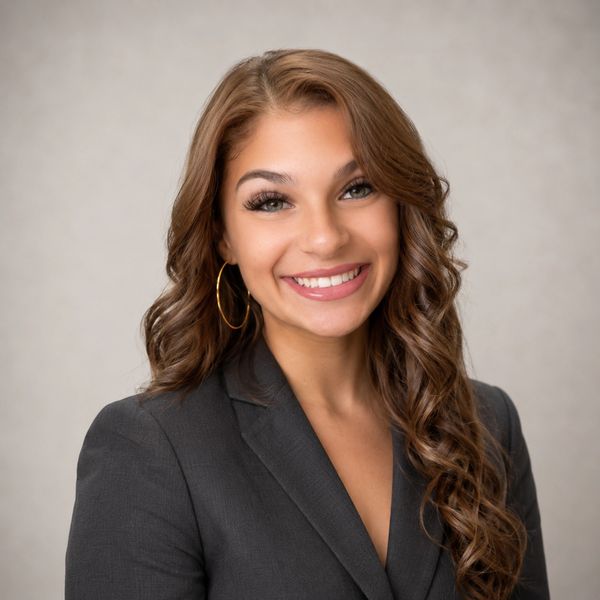 Young woman smiling in professional attire.