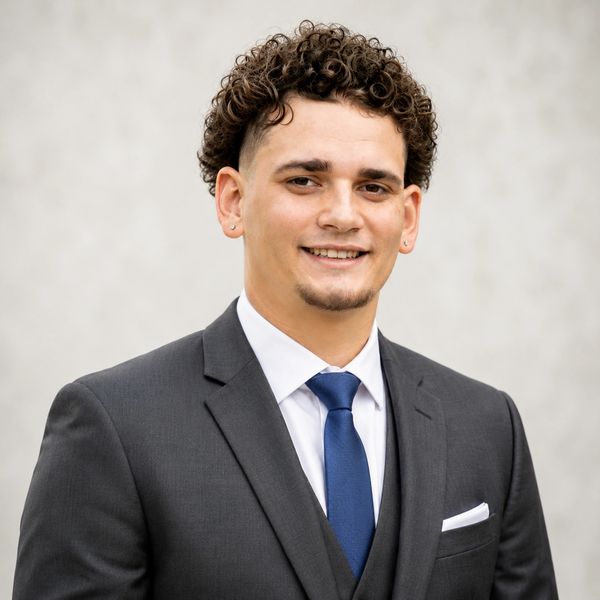 Young man in a suit smiling.