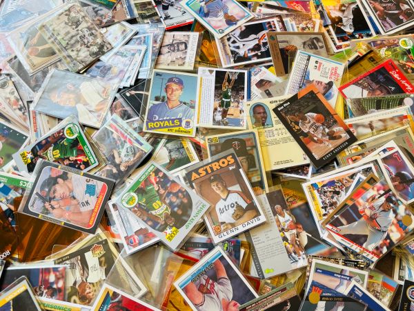 A scattered collection of vintage sports trading cards, mostly baseball and basketball.