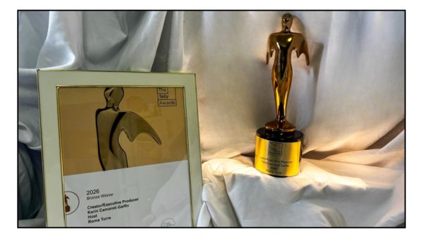 Bronze Telly Award statue and certificate on white cloth.