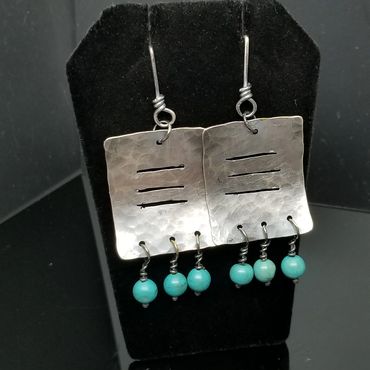 Handcrafted silver earrings with turquoise beads and hammered texture.