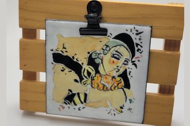 Small hand painted enamel tile with painted Degas Style Woman, held by a clip on a wooden stand. Si
