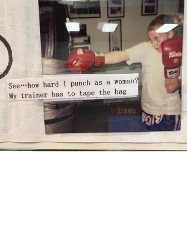 Woman boxer punches a taped bag, showing her strength in training.