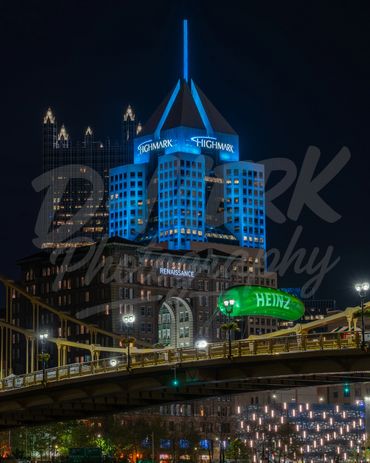 Heinz Picklesburgh pickle lit up at night on Pittsburgh bridge.