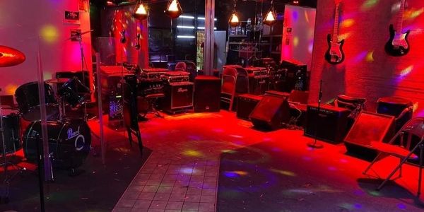 Music rehearsal room with colorful stage lighting and instruments.
