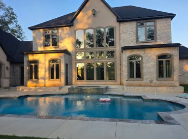 Modern brick house with large windows and swimming pool.