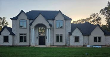Elegant two-story house with large pillars and multiple windows.