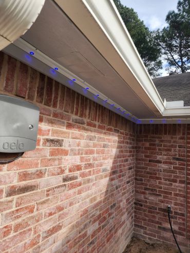Brick corner exterior with blue LED lights under eaves.