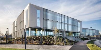 Modern office building with glass facade and landscaping.